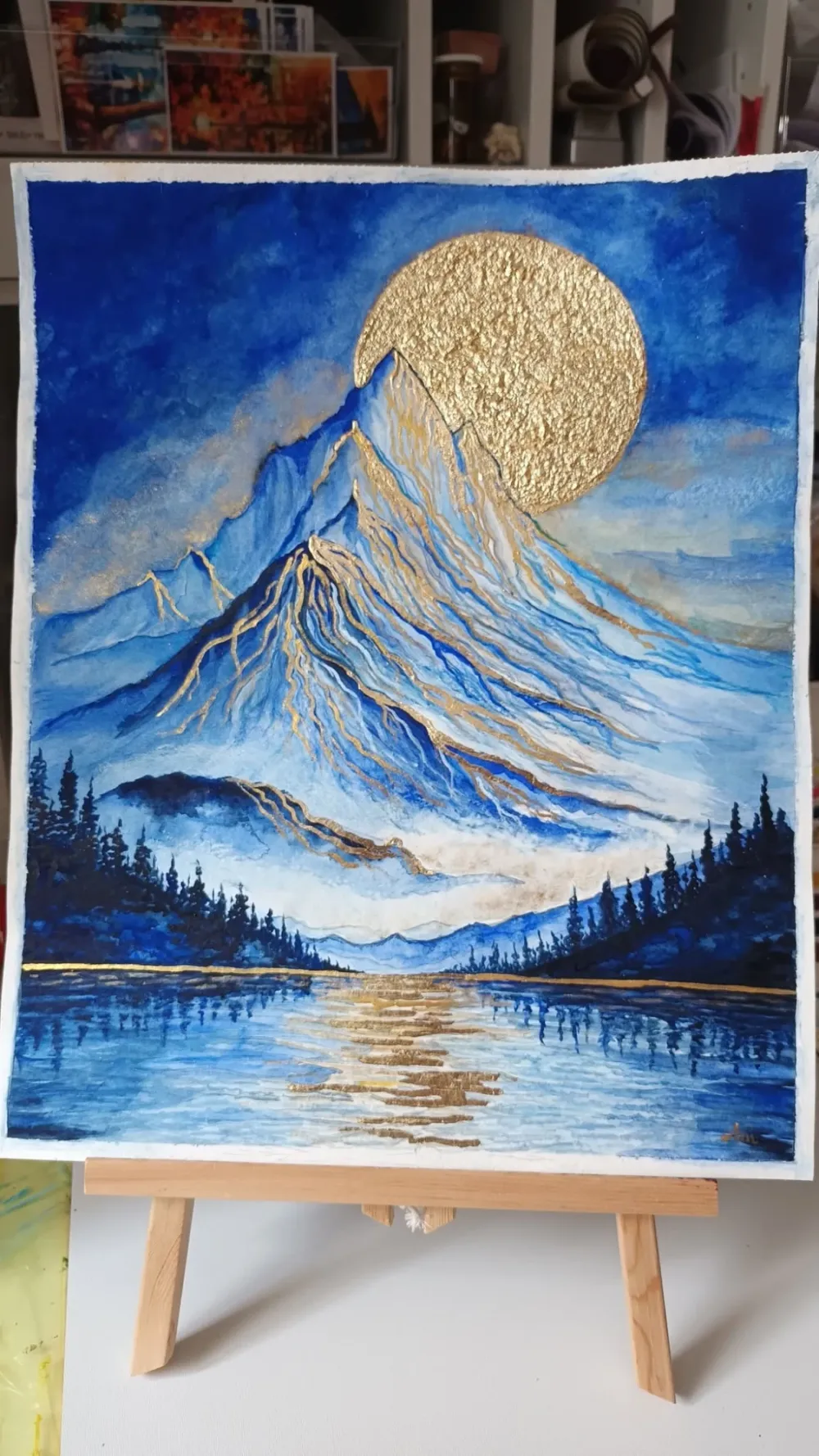 Császár's finished gold leaf mountain painting on an easel